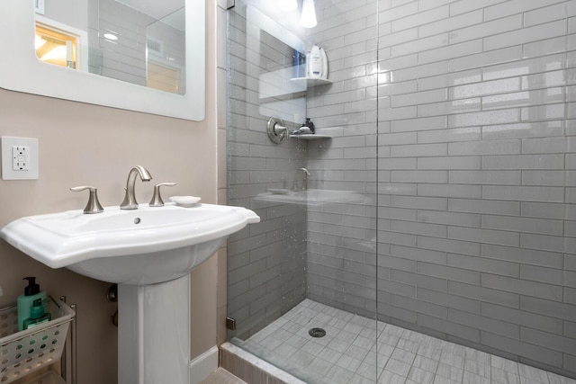 bathroom with a stall shower and a sink