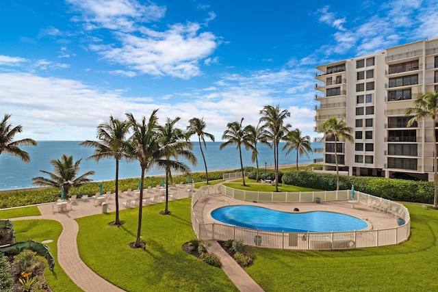 view of swimming pool featuring a water view and a lawn