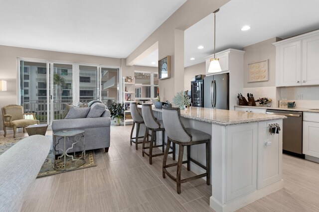 kitchen featuring white cabinets, hanging light fixtures, appliances with stainless steel finishes, and tasteful backsplash