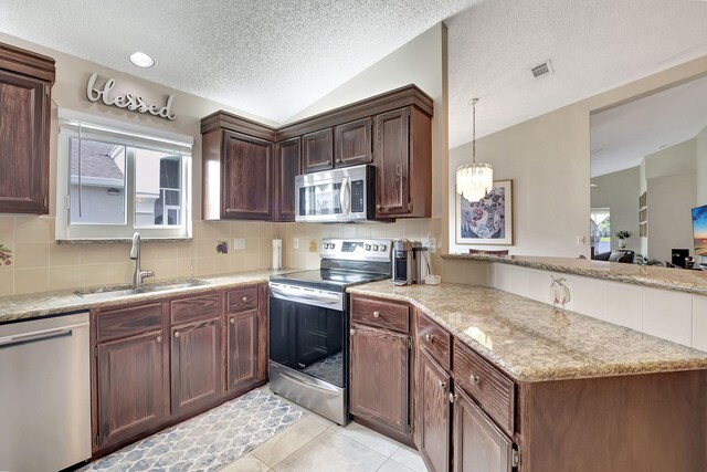 kitchen with sink, stainless steel appliances, light tile patterned flooring, and backsplash