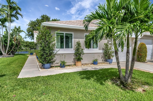 view of home's exterior featuring a shingled roof, a water view, stucco siding, a lawn, and a garage