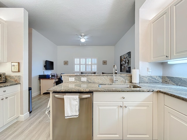 kitchen featuring white cabinets, stainless steel dishwasher, light hardwood / wood-style floors, and light stone countertops