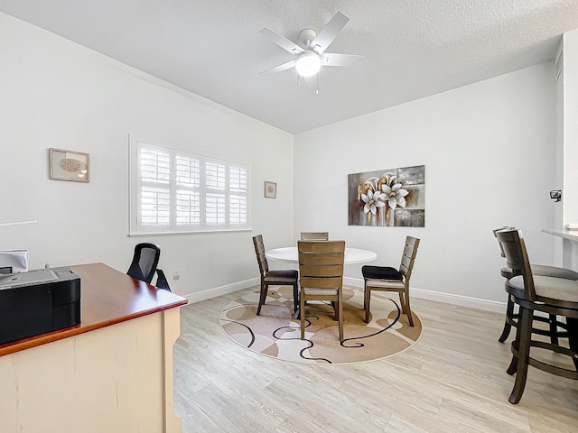 dining area with ceiling fan, a textured ceiling, and light hardwood / wood-style floors