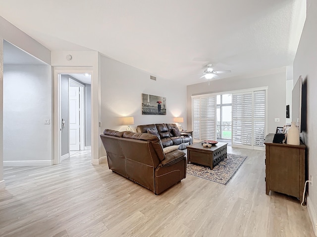 living room featuring ceiling fan and light hardwood / wood-style flooring