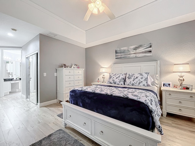 bedroom featuring ceiling fan, connected bathroom, and light hardwood / wood-style floors