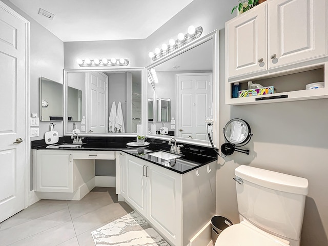 bathroom featuring dual vanity, tile patterned flooring, and toilet