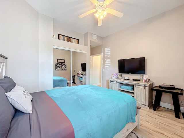 bedroom with ceiling fan, a closet, and light hardwood / wood-style floors