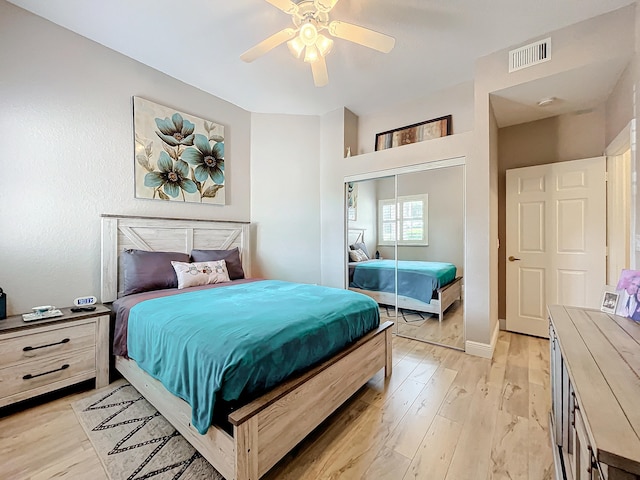 bedroom featuring ceiling fan, light hardwood / wood-style floors, and a closet