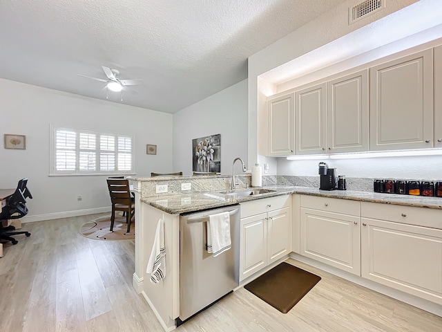 kitchen with kitchen peninsula, light stone counters, sink, and dishwasher