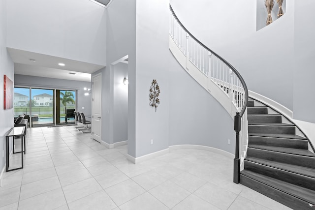 staircase featuring tile patterned flooring and a towering ceiling