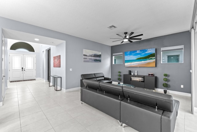 living room featuring ceiling fan and a textured ceiling