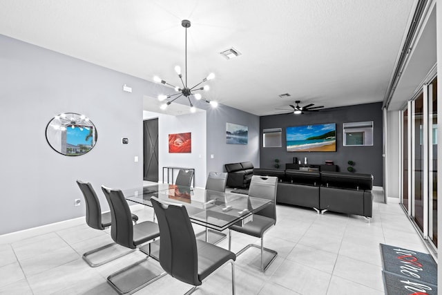 dining room with ceiling fan with notable chandelier and a textured ceiling