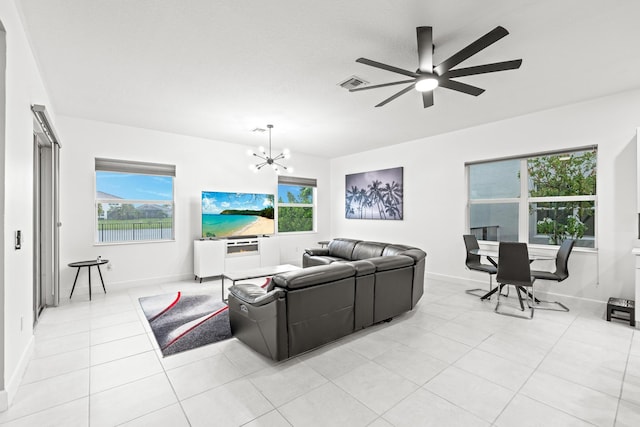 living room featuring ceiling fan with notable chandelier and light tile patterned flooring