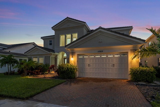 view of front of property with a garage and a yard