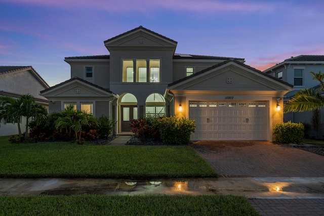 view of front facade with a yard and a garage