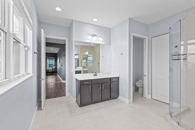 bathroom with tile patterned floors, toilet, a shower with door, and vanity