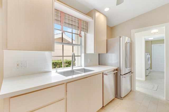 kitchen with light tile patterned floors, decorative backsplash, appliances with stainless steel finishes, sink, and washer / clothes dryer