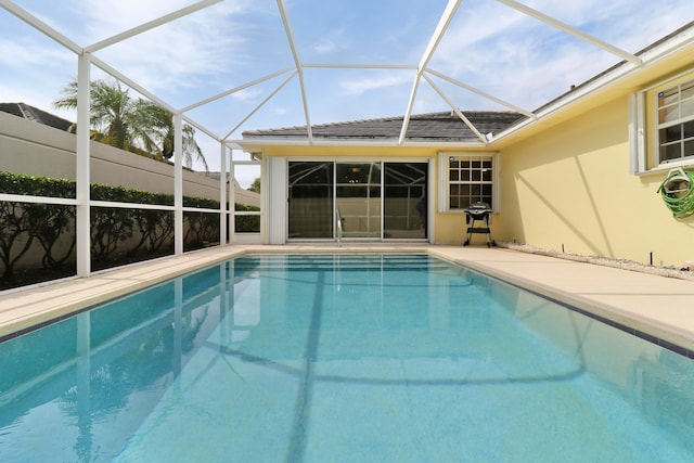 view of swimming pool featuring a lanai