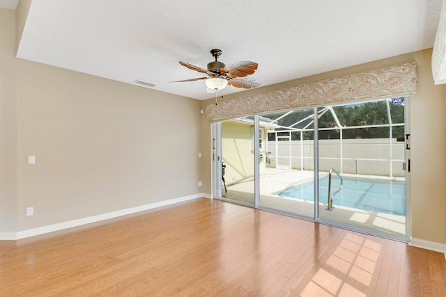 empty room featuring ceiling fan, a textured ceiling, and hardwood / wood-style floors