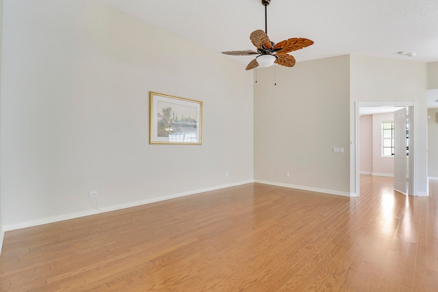 empty room with ceiling fan and light hardwood / wood-style floors