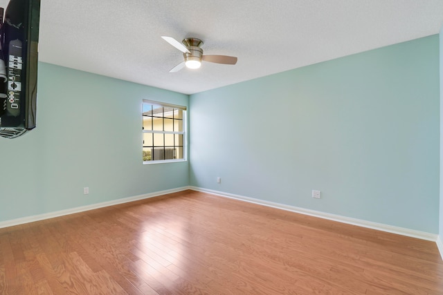 spare room with a textured ceiling, hardwood / wood-style floors, and ceiling fan