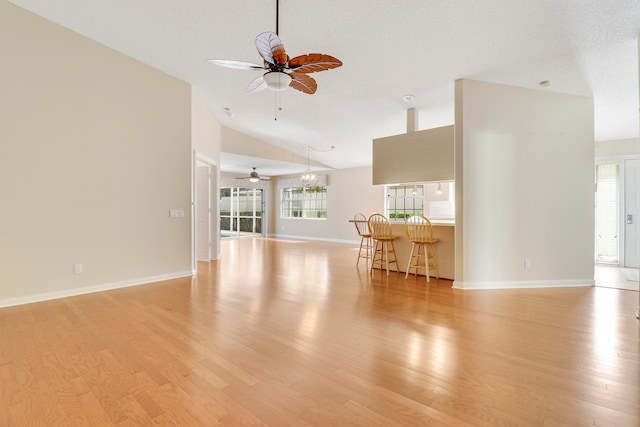 unfurnished living room with high vaulted ceiling, ceiling fan, and light hardwood / wood-style floors