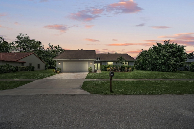 ranch-style house featuring a lawn and a garage