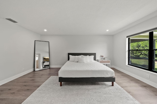 bedroom featuring a textured ceiling and hardwood / wood-style flooring