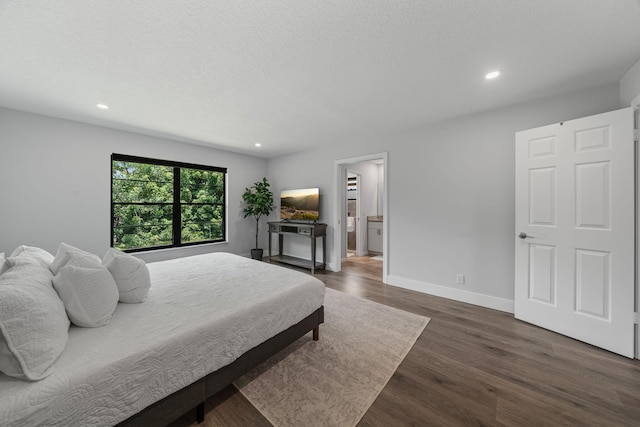 bedroom featuring wood-type flooring and ensuite bath