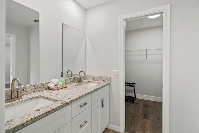 bathroom with dual vanity and hardwood / wood-style floors