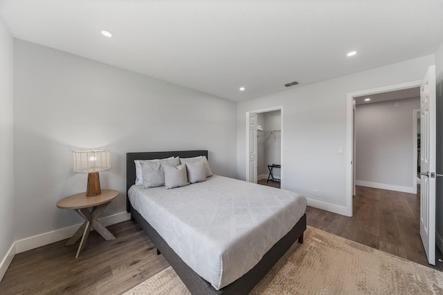 bedroom featuring hardwood / wood-style floors, a closet, and a walk in closet