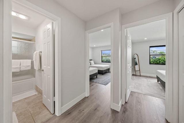 corridor featuring a healthy amount of sunlight and light hardwood / wood-style floors