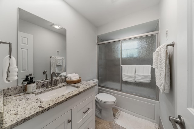 full bathroom featuring tile patterned floors, vanity, toilet, and enclosed tub / shower combo