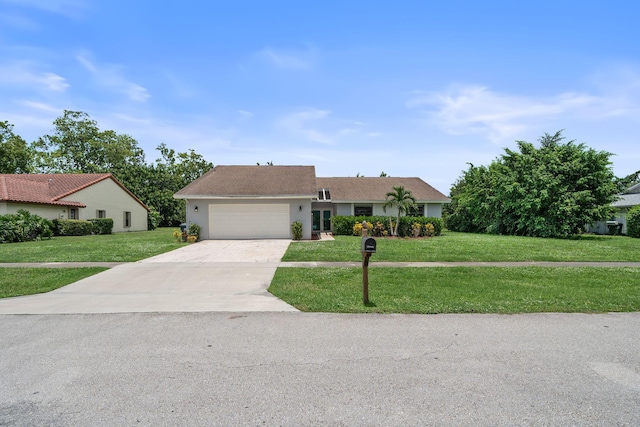 view of front of home with a front yard and a garage