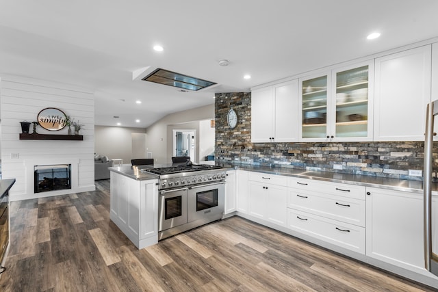 kitchen with white cabinets, kitchen peninsula, double oven range, and dark wood-type flooring