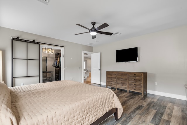 bedroom with a walk in closet, a closet, ceiling fan, and dark hardwood / wood-style flooring