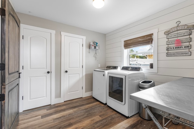 washroom featuring wooden walls, dark hardwood / wood-style flooring, and separate washer and dryer