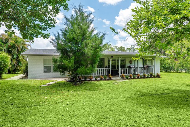 back of property featuring a porch and a yard