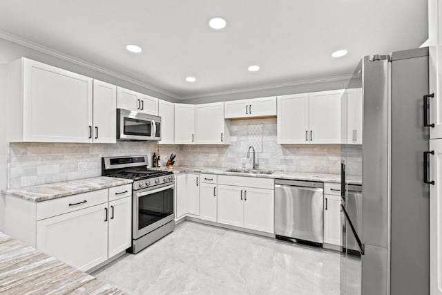 kitchen with appliances with stainless steel finishes, white cabinetry, light stone counters, and sink