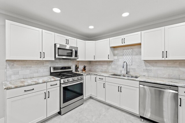 kitchen featuring crown molding, appliances with stainless steel finishes, white cabinetry, and sink