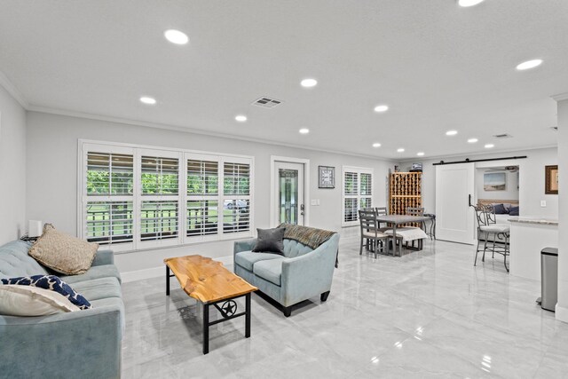 living room with a barn door and crown molding