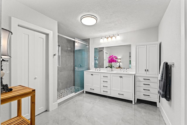 bathroom featuring a textured ceiling, vanity, and an enclosed shower