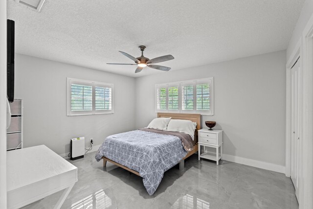 bedroom with a textured ceiling, ceiling fan, and a closet