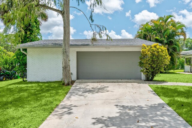 ranch-style house featuring a front yard and a garage