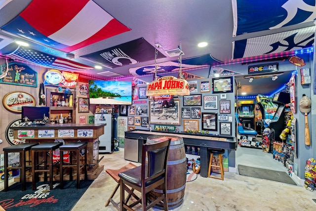 playroom with concrete floors, indoor bar, and water heater