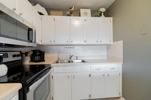 kitchen with white cabinetry, sink, stainless steel appliances, and tasteful backsplash