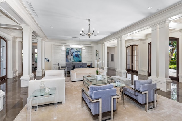 living room with decorative columns, an AC wall unit, crown molding, and a chandelier