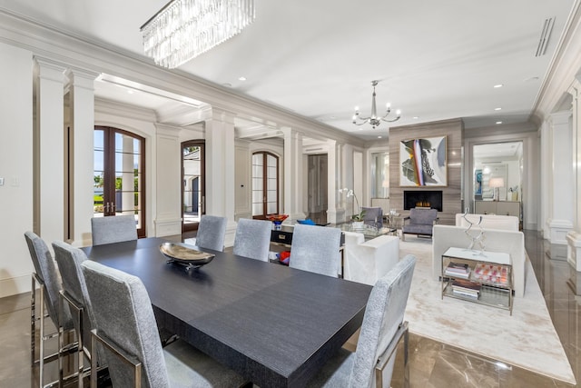 dining space featuring ornate columns, crown molding, french doors, and an inviting chandelier