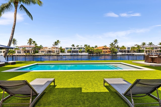 view of pool featuring a yard and a water view