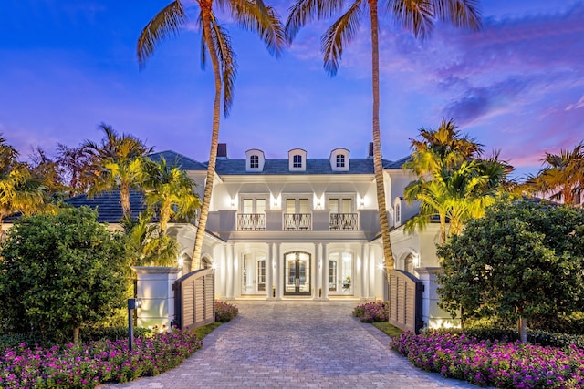 view of front of house featuring a balcony and french doors